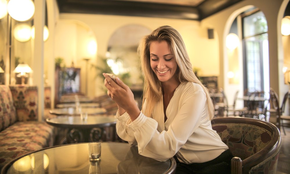 Mujer en un bar hablando por teléfono